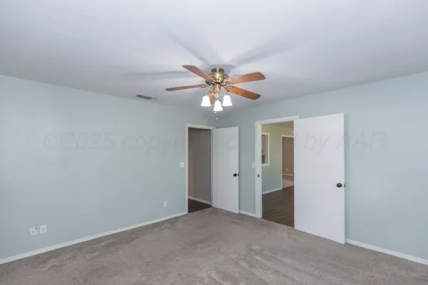an empty room and chandelier fan