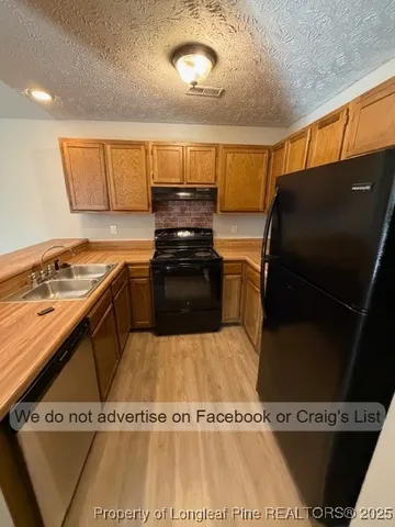 a kitchen with a refrigerator and a stove top oven