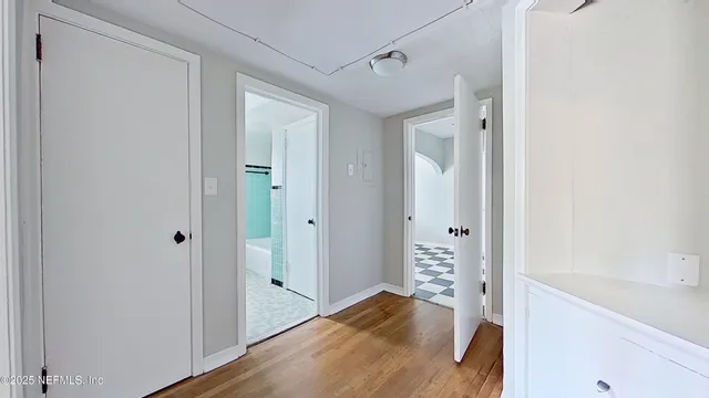 a view of a hallway with wooden floor and closet