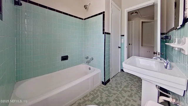 a bathroom with a tub a sink and mirror