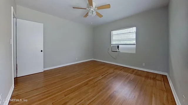 wooden floor in an empty room with a window