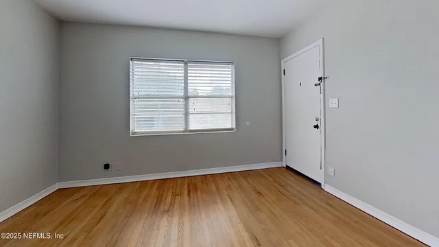 wooden floor in an empty room with a window