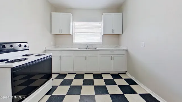 a kitchen with a checkered floor and white cabinets