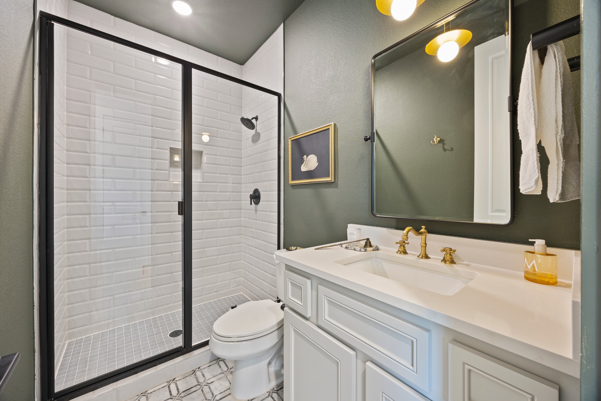 1204 Addison Lane Georgetown, TX 78628 - Photo 21 of 35 The third bathroom has a beautiful hunter-green palette and striking geometric floor tiling. The walk-in shower is finished with classic white subway tile and a sleek matte black frame, while brushed gold hardware and designer globe lighting add a sophisticated, modern touch.