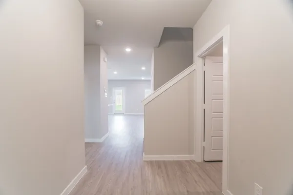 a view of hallway with stairs and wooden floor