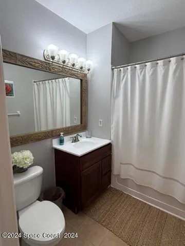 a bathroom with a sink vanity mirror and toilet