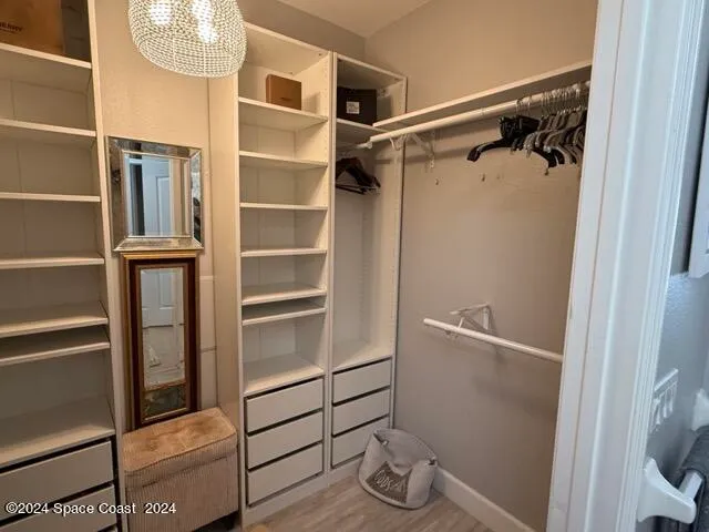 a view of walk in closet with empty racks
