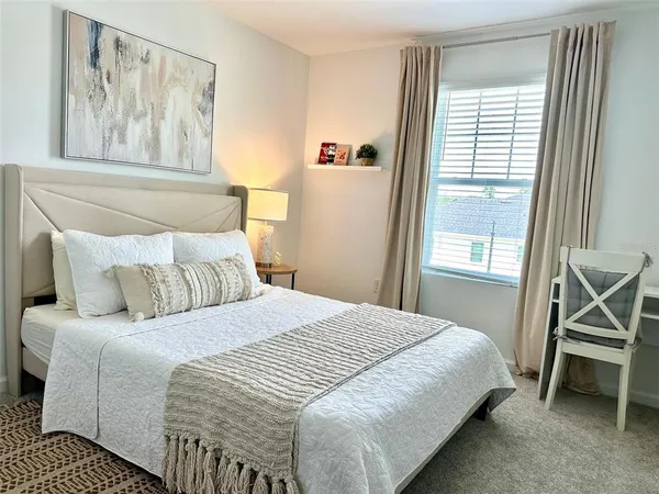 a bedroom with a bed and a window