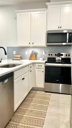 a kitchen with stainless steel appliances granite countertop a sink and a stove