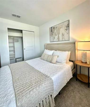 a bedroom with a bed and a painting on the wall