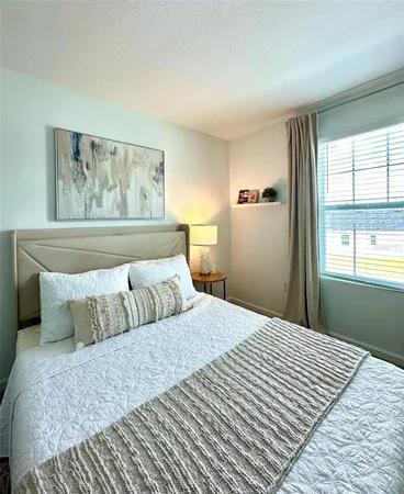 a bedroom with a large bed and a window