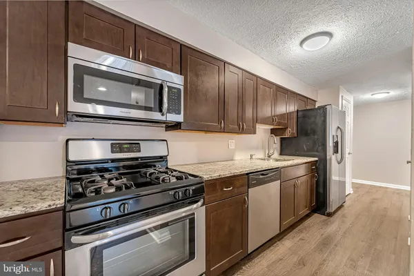 a kitchen with stainless steel appliances granite countertop a stove microwave and cabinets