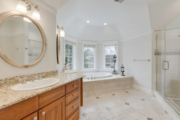 a spacious bathroom with a tub sink and mirror