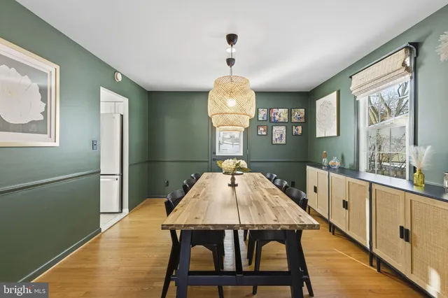 a dining room with wooden floor a chandelier a wooden table and chairs