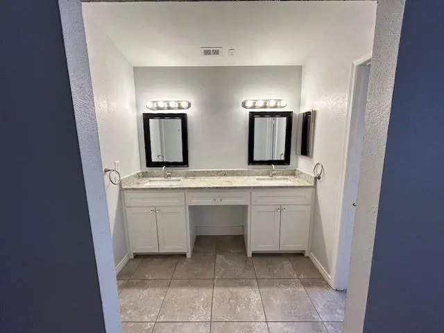 a bathroom with a double vanity sink and a mirror