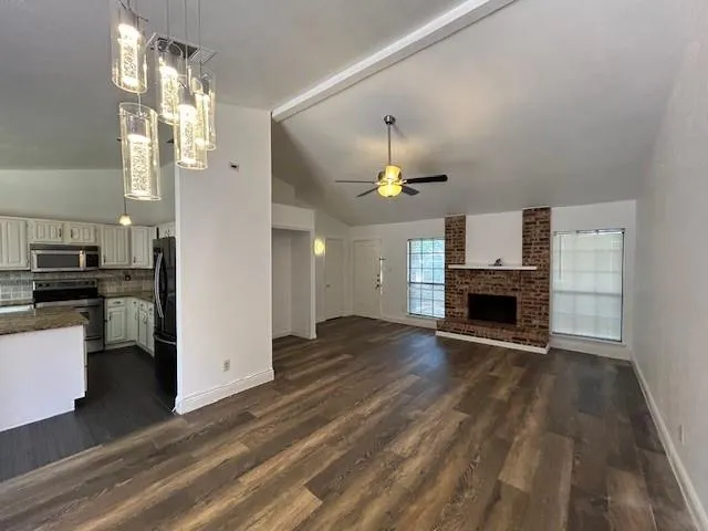 a kitchen with kitchen island a counter top space a refrigerator and cabinets