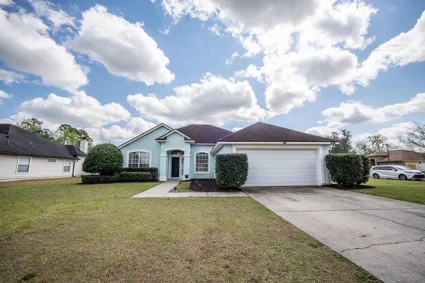 a front view of a house with a yard and garage