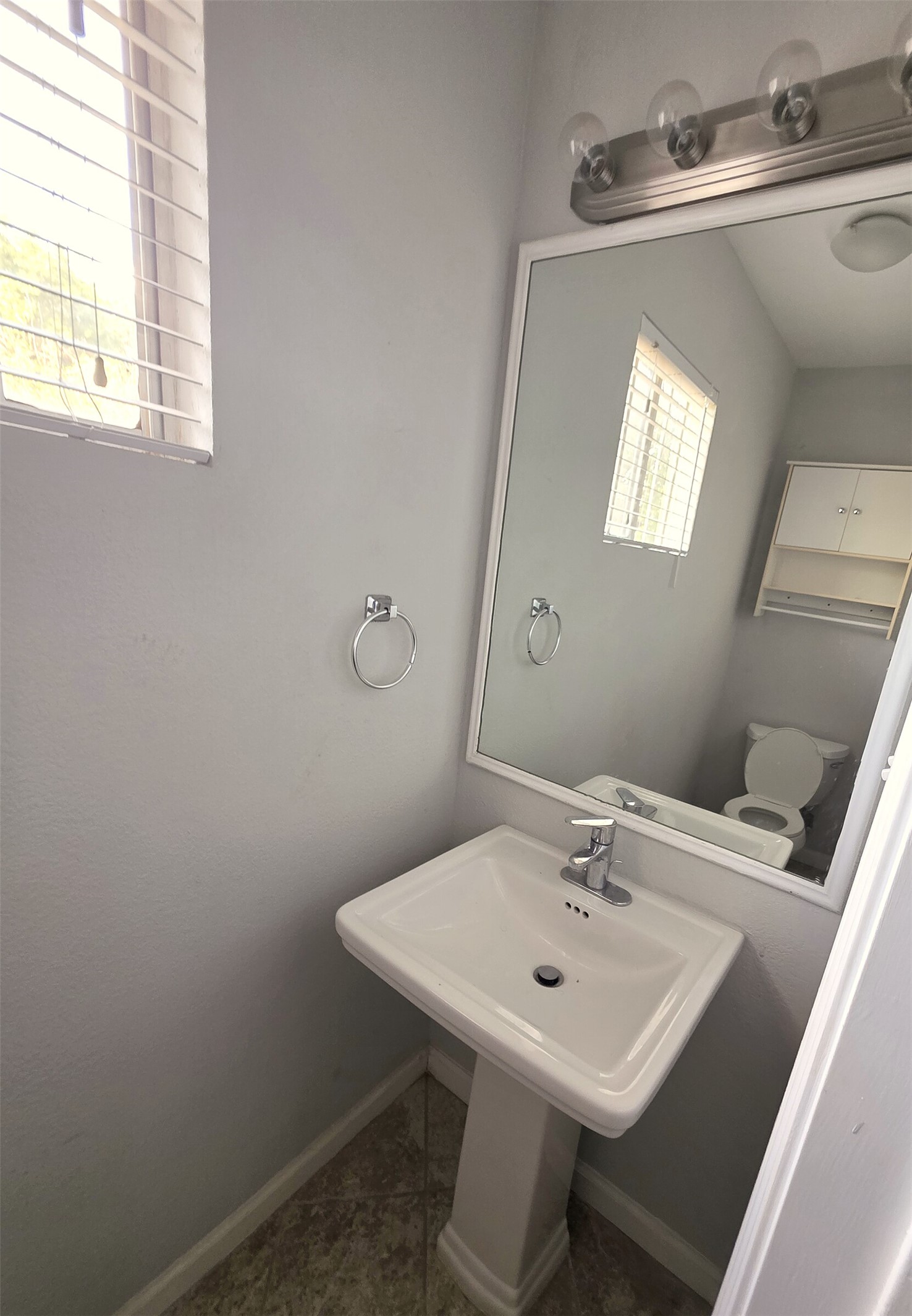 703 Castle Ridge Road, Unit B Austin, TX 78746 - Photo 14 of 18 A pedestal sink paired with tile flooring defines this classic powder room.