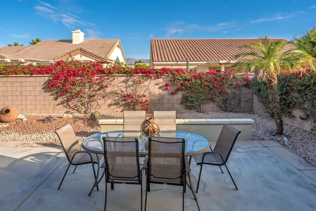 a backyard of a house with fountain table and chairs