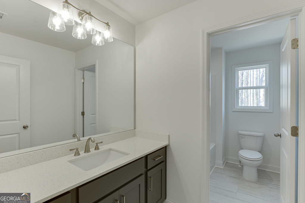 1003 Lakeview Drive Commerce, GA 30529 - Photo 27 of 48 a bathroom with a granite countertop sink a toilet and a mirror