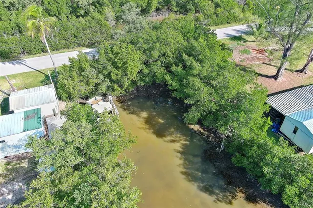 an aerial view of residential house with outdoor space and trees all around