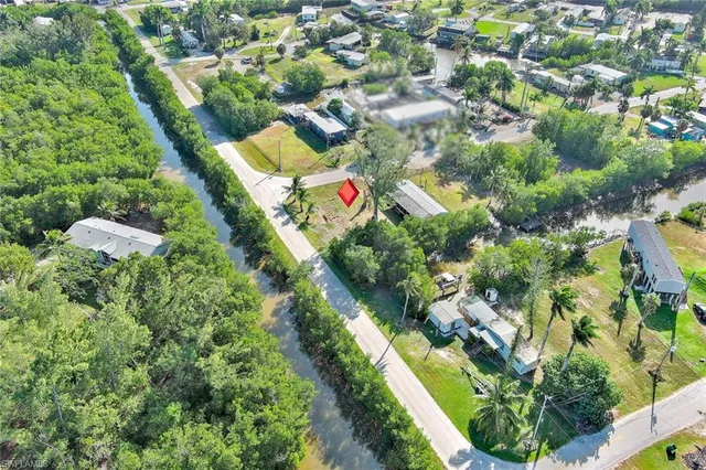an aerial view of residential houses with outdoor space and trees all around