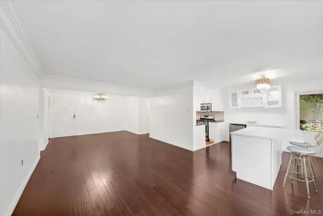 a view of a kitchen with wooden floor and electronic appliances
