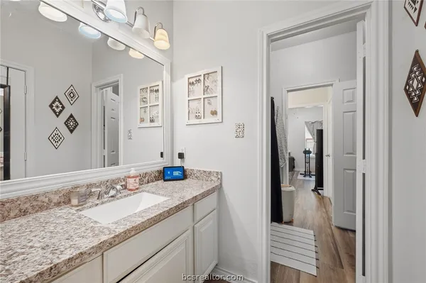 a bathroom with a granite countertop sink a mirror and a shower
