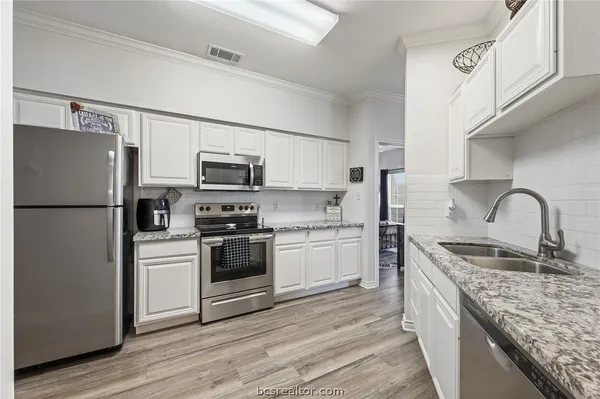 a kitchen with stainless steel appliances granite countertop a refrigerator stove and sink