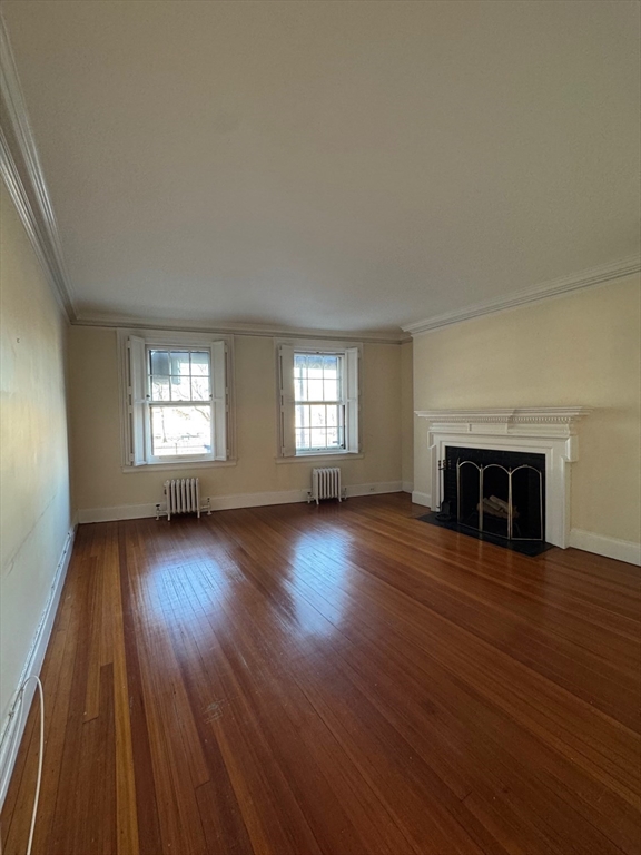 112 Pinckney Street, Unit 11 Boston, MA 02114 - Photo 5 of 16 an empty room with wooden floor and windows