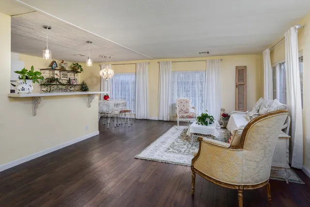 a kitchen with stainless steel appliances kitchen island wooden floors and view living room