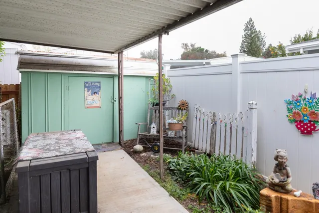 a backyard of a house with plants and outdoor seating