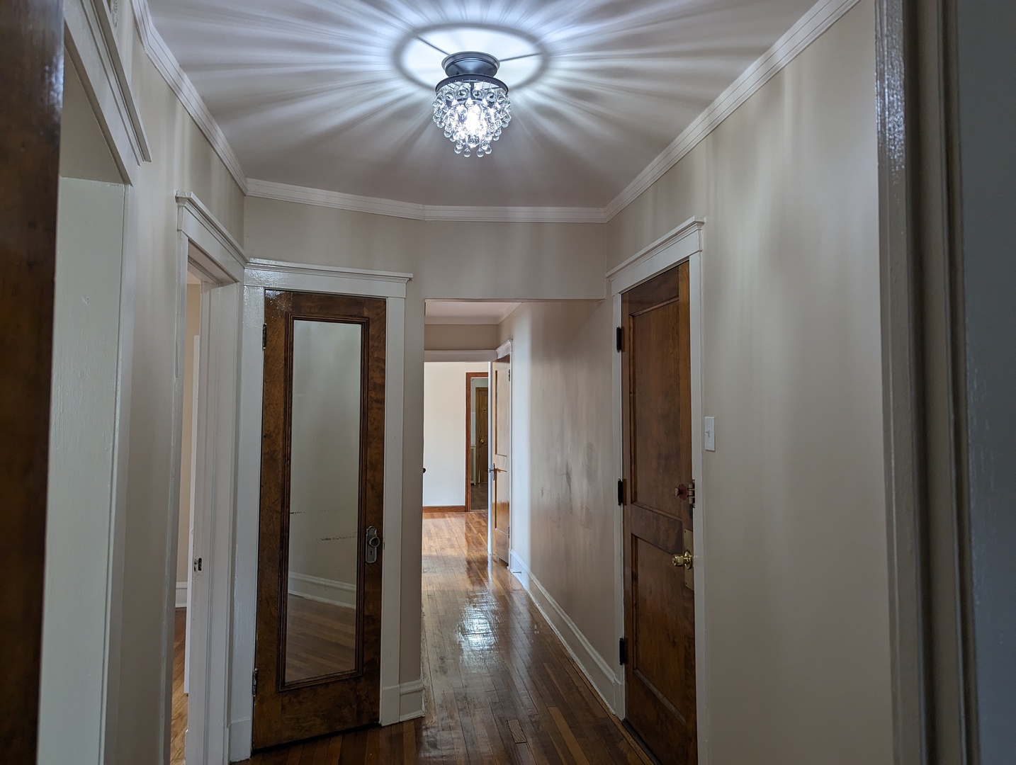 6730 South Ridgeland Avenue, Unit 2 Chicago, IL 60649 - Photo 2 of 12 a view of a hallway with a chandelier fan and furniture