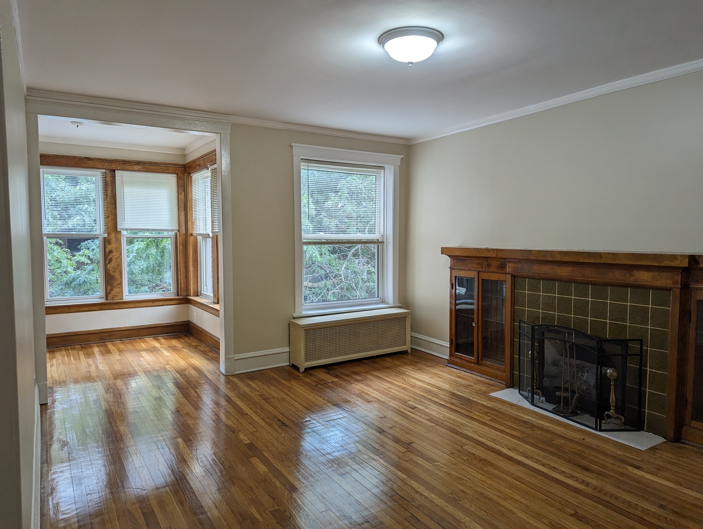 6730 South Ridgeland Avenue, Unit 2 Chicago, IL 60649 - Photo 3 of 12 a view of an empty room with wooden floor and a window