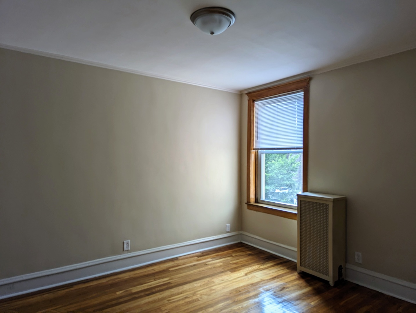 6730 South Ridgeland Avenue, Unit 2 Chicago, IL 60649 - Photo 5 of 12 a view of an empty room with wooden floor and a window