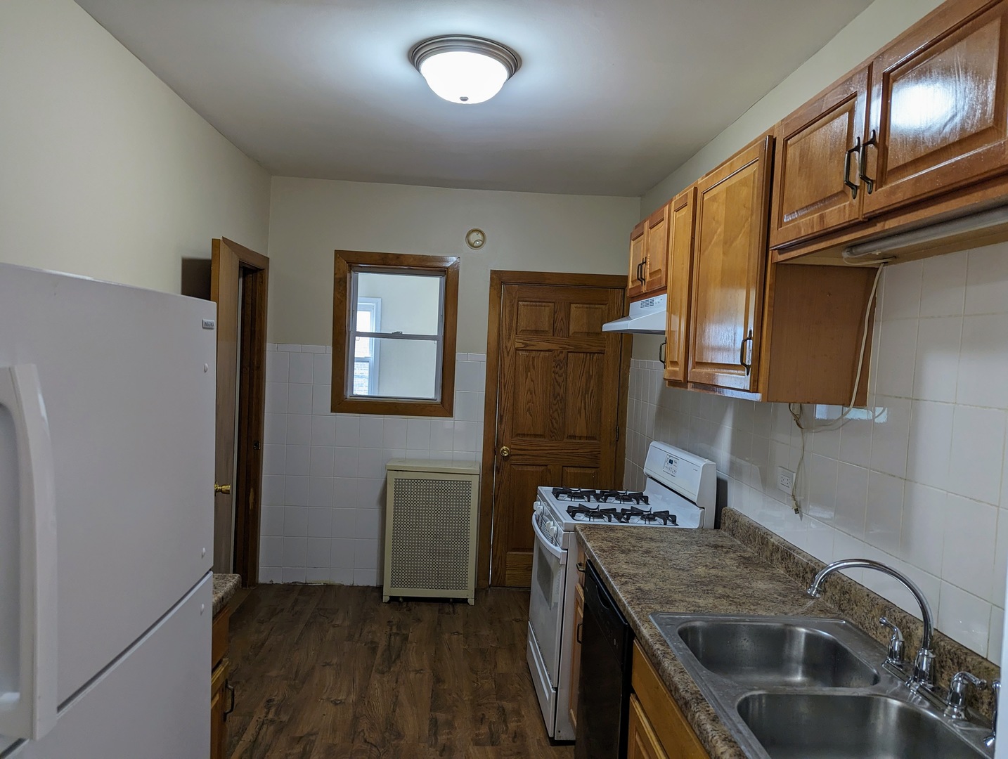 6730 South Ridgeland Avenue, Unit 2 Chicago, IL 60649 - Photo 7 of 12 a kitchen with stainless steel appliances granite countertop a sink stove and refrigerator