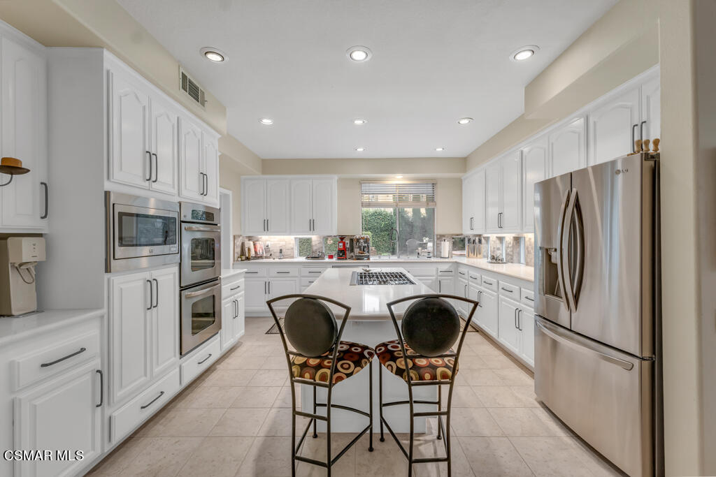 4372 Clearwood Road Moorpark, CA 93021 - Photo 20 of 51 a kitchen with stainless steel appliances granite countertop a refrigerator a stove a sink a dining table and chairs