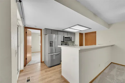 a kitchen with refrigerator cabinets and wooden floor