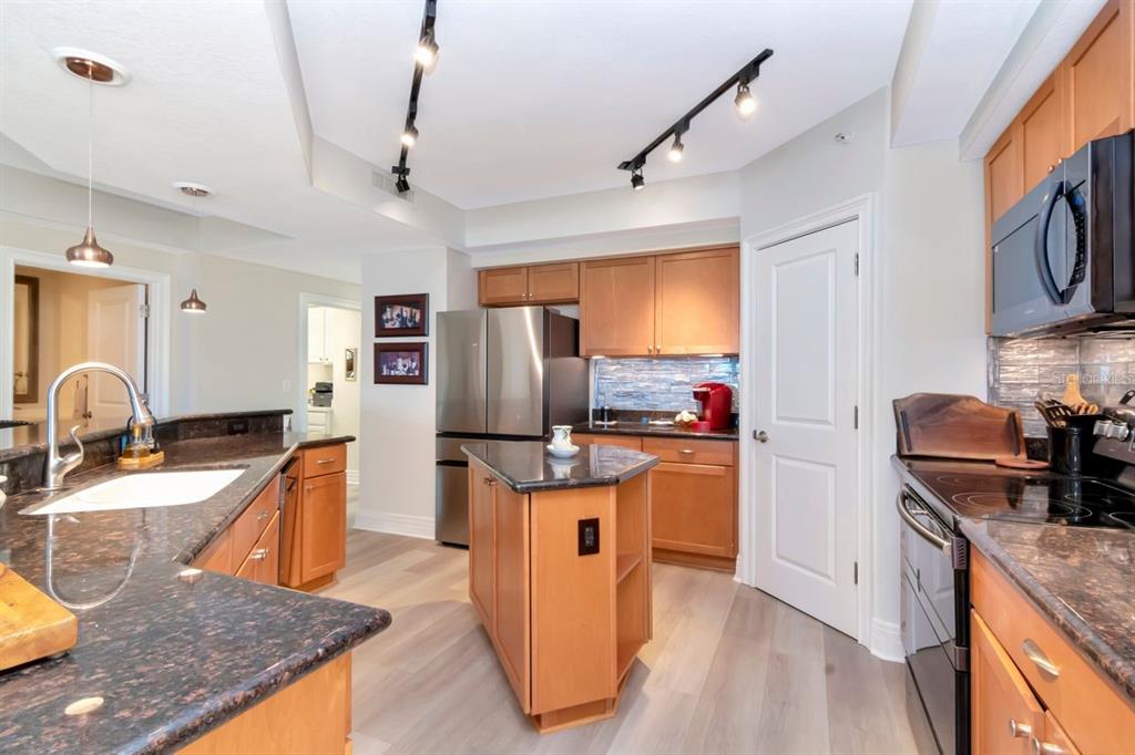 1350 Gulf Boulevard, Unit 301 Clearwater Beach, FL 33767 - Photo 15 of 75 a kitchen with stainless steel appliances granite countertop a sink stove and refrigerator