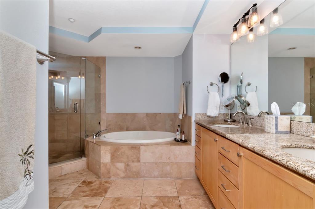 1350 Gulf Boulevard, Unit 301 Clearwater Beach, FL 33767 - Photo 20 of 75 a spacious bathroom with a tub sink and mirror