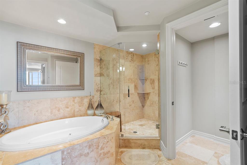 1350 Gulf Boulevard, Unit 301 Clearwater Beach, FL 33767 - Photo 24 of 75 a bathroom with a tub a sink and a shower