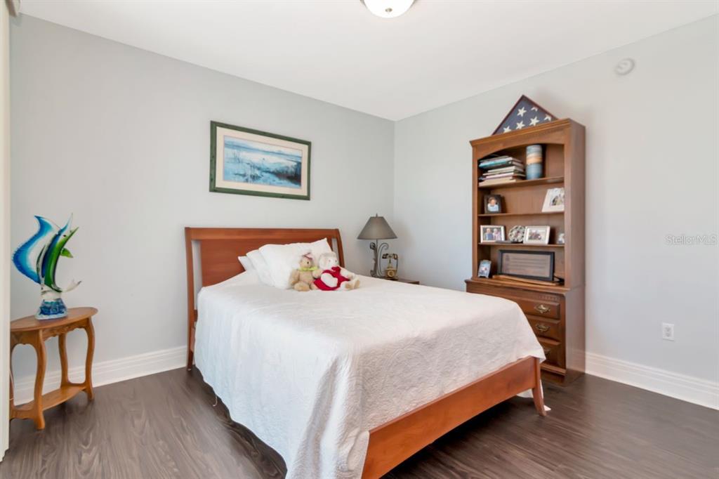 1350 Gulf Boulevard, Unit 301 Clearwater Beach, FL 33767 - Photo 25 of 75 a bedroom with a bed and a bookshelf