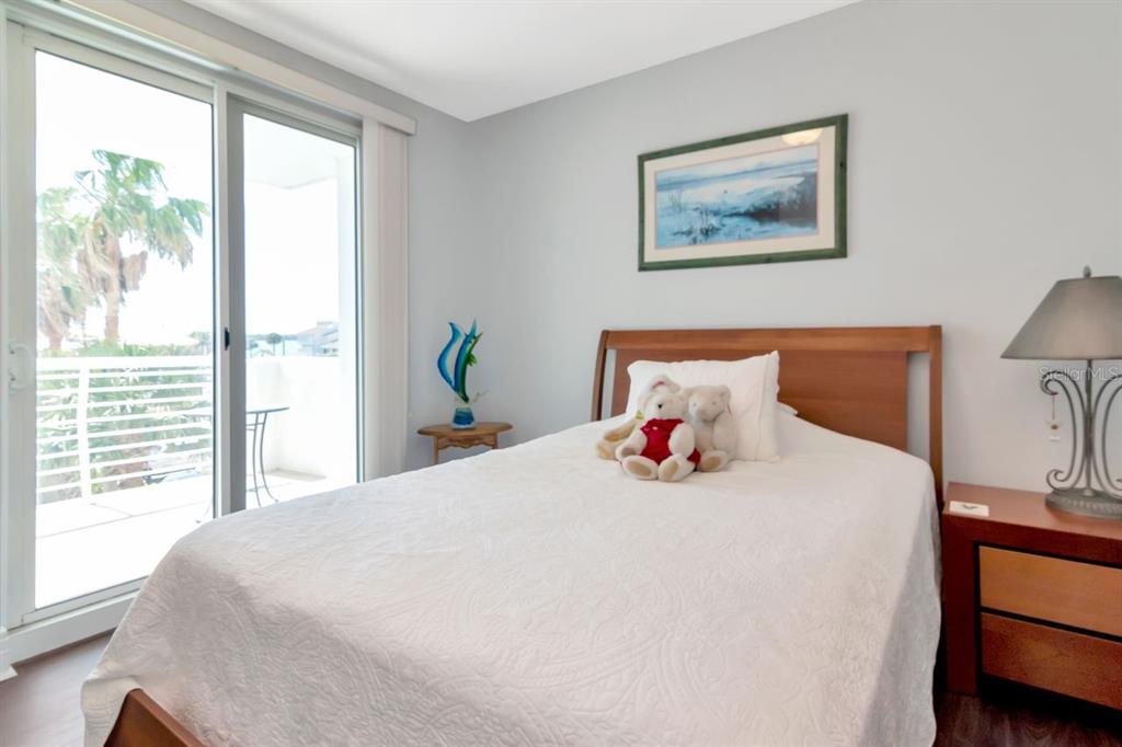 1350 Gulf Boulevard, Unit 301 Clearwater Beach, FL 33767 - Photo 26 of 75 a bedroom with a bed and wooden floor