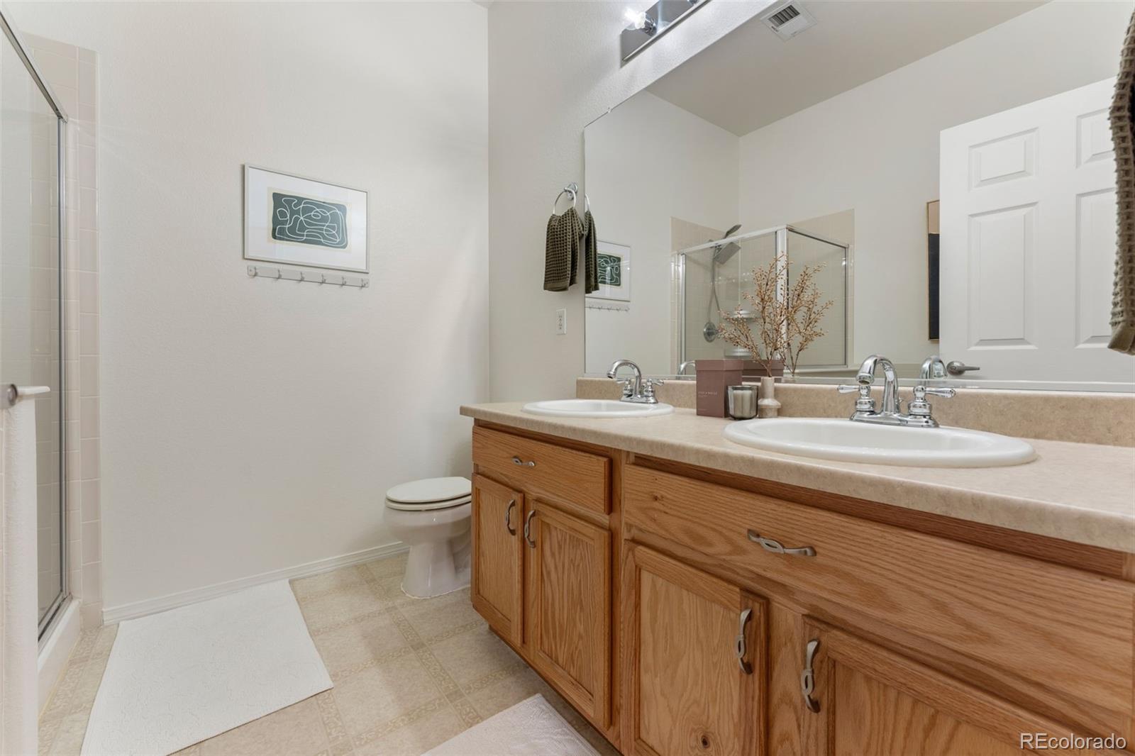 8420 Canyon Rim Trail, Unit 305 Parker, CO 80134 - Photo 16 of 44 a bathroom with a double vanity sink and a toilet