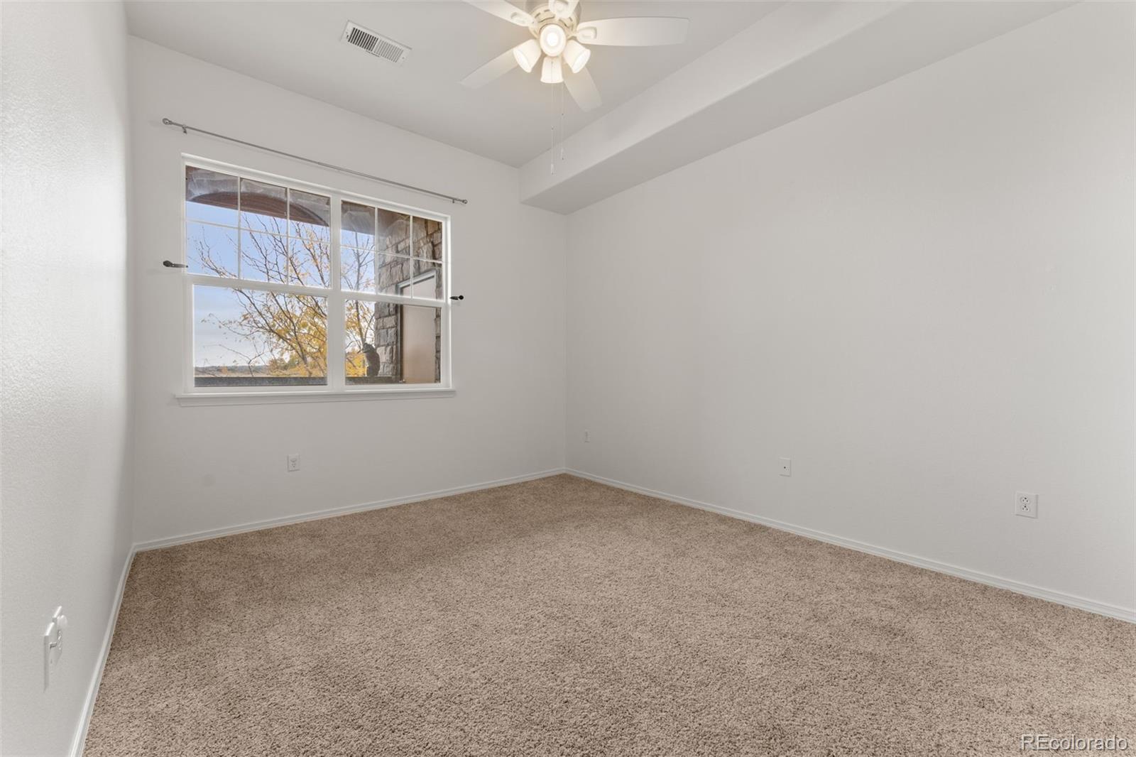 8420 Canyon Rim Trail, Unit 305 Parker, CO 80134 - Photo 19 of 44 an empty room with windows and fan