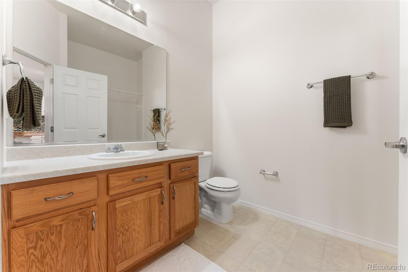 8420 Canyon Rim Trail, Unit 305 Parker, CO 80134 - Photo 21 of 44 a bathroom with a toilet sink and mirror