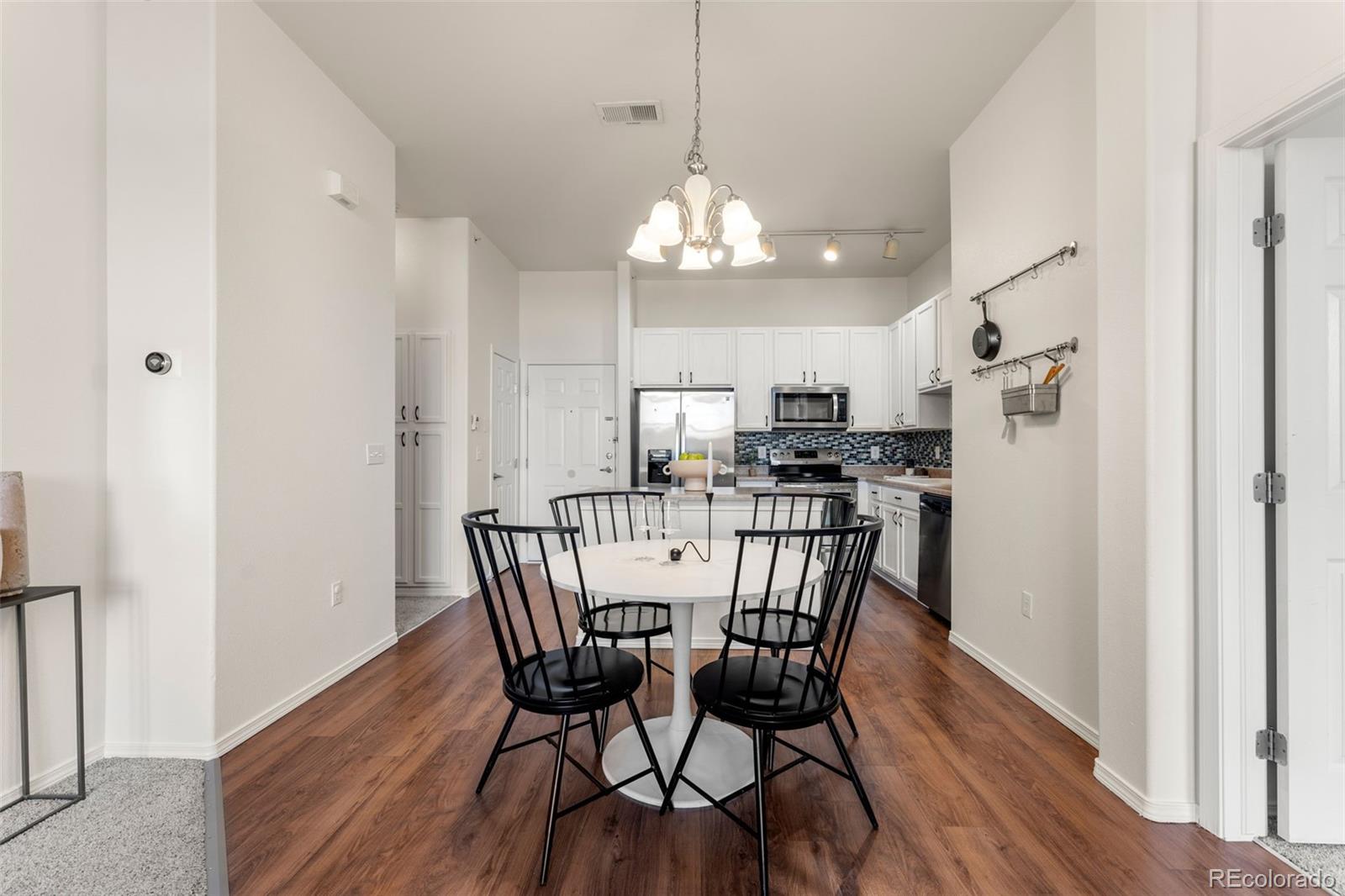 8420 Canyon Rim Trail, Unit 305 Parker, CO 80134 - Photo 36 of 44 a view of a dining room with furniture wooden floor and chandelier