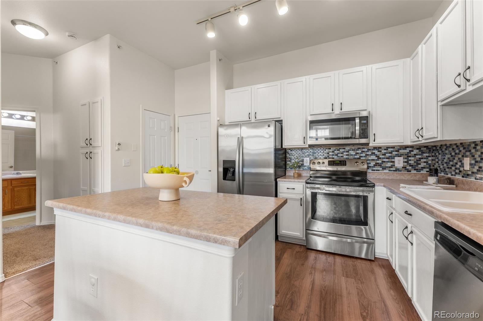 8420 Canyon Rim Trail, Unit 305 Parker, CO 80134 - Photo 38 of 44 a kitchen with stainless steel appliances a sink a stove a microwave a refrigerator a counter top space and cabinets