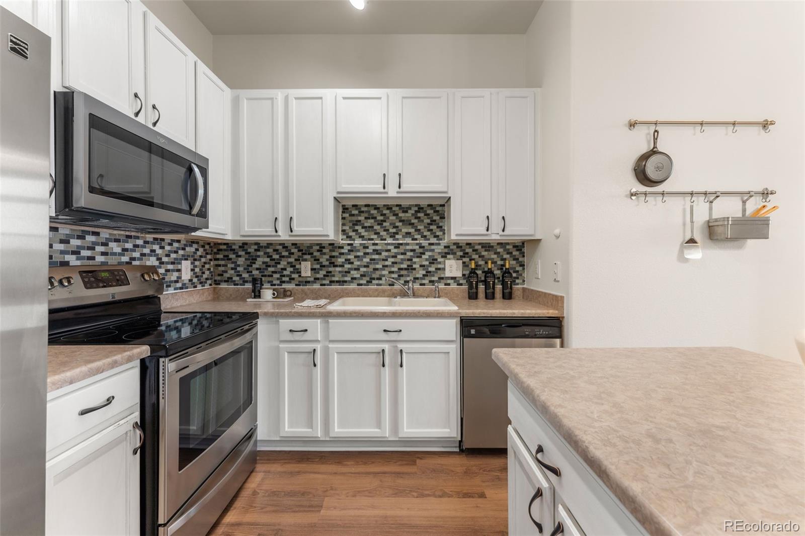 8420 Canyon Rim Trail, Unit 305 Parker, CO 80134 - Photo 9 of 44 a kitchen with stainless steel appliances granite countertop a stove a sink and a microwave