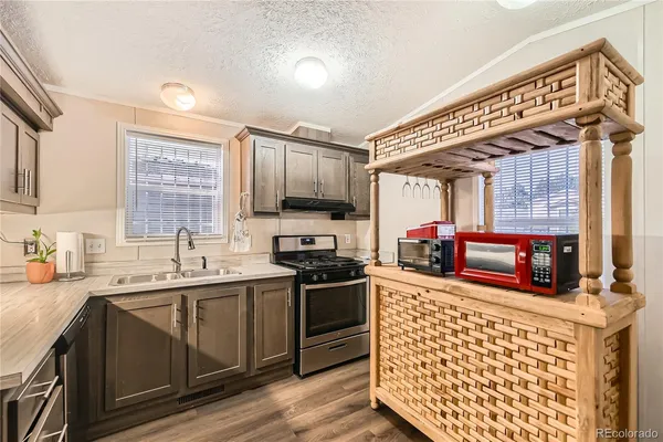 a kitchen with stainless steel appliances sink stove microwave and cabinets